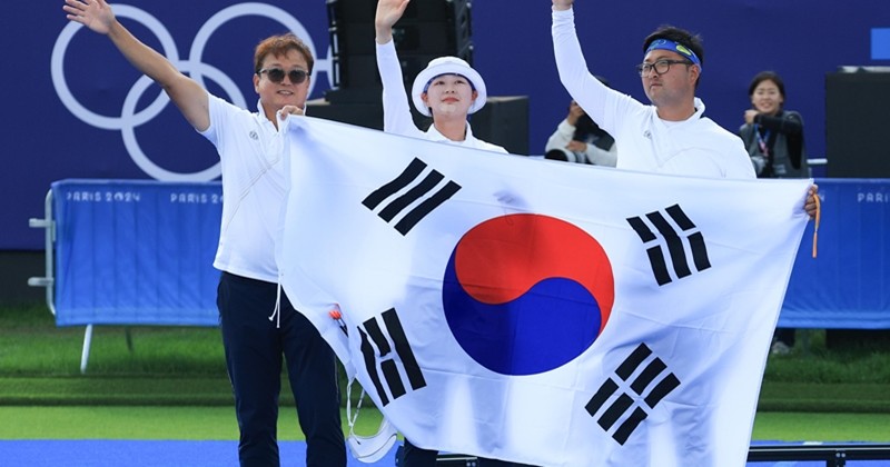 대한민국 양궁 대표팀 김우진, 임시현, 박성수 감독(오른쪽부터)이 프랑스 파리 앵발리드에서 진행된 파리올림픽 양궁 혼성 단체 금메달 결정전 독일의 미셸 크로펜, 플로리안 칼룬드 조와의 경기에서 금메달을 확정지은 후 기뻐하고 있다. 사진은 2024년 8월 / 뉴스1
