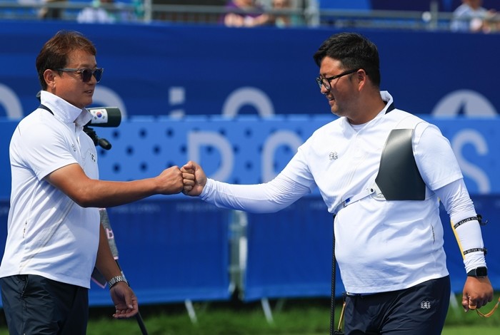 대한민국 남자 양궁 대표팀 김우진 선수가 프랑스 파리 앵발리드에서 2024 파리올림픽 남자 양궁 개인전 준결승 대한민국의 이우석 선수와의 경기에서 슛오프 접전 끝에 승리한 후 박성수 감독과 기뻐하고 있다. 사진은 2024년 8월 / 뉴스1