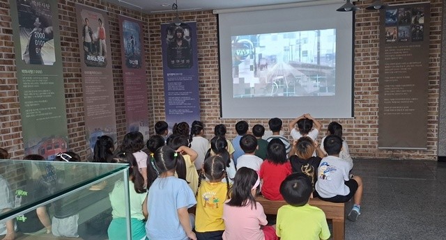 철도문화체험관을 방문한 어린이들이 기차의 역사에 대한 영상을 시청중이다