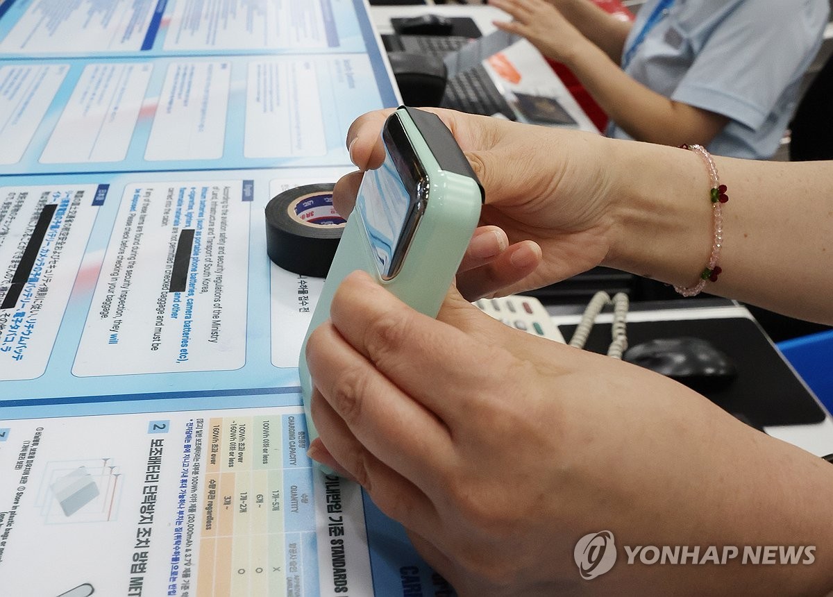 1일 오후 부산 강서구 김해국제공항 대한항공 수속카운터에서 항공사 직원이 승객의 보조배터리 충전 연결부분에 절연 테이프를 부착하고 있다. / 연합뉴스