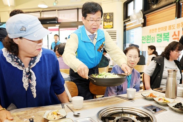 박병규 광산구청장이 어룡동에서 진행된 ‘천원한끼 나만의 밥상’ 행사에 참석해 주민에게 음식을 전달하고 있다.