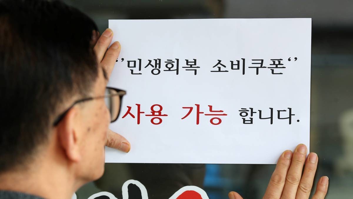 민생회복 소비쿠폰 사용 가능 안내문을 붙이고 있다. / 뉴스1