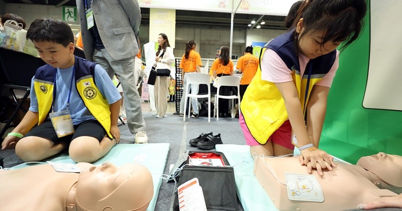 경기 고양시 일산서구 킨텍스에서 열린 '2025 어린이 안전 박람회'에서 어린이들이 심폐소생술(CPR) 및 자동심장충격기(AED) 사용법을 배우고 있다. / 뉴스1
