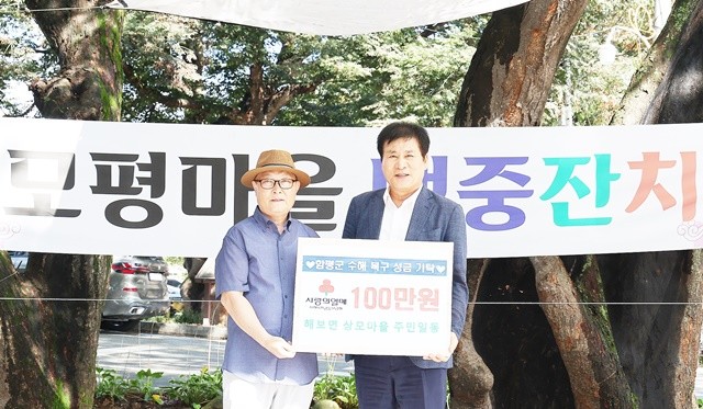 윤석빈 모평마을 이장(왼쪽) 수해 피해 100만원 성금 기부하고 이상익 함평군수와 기념촬영을 하고 있다.