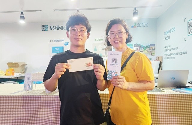 하맥축제 현장 뽑기이벤트 당첨자가 강진사랑상품권을 들고 기념촬영을 하고 있다.