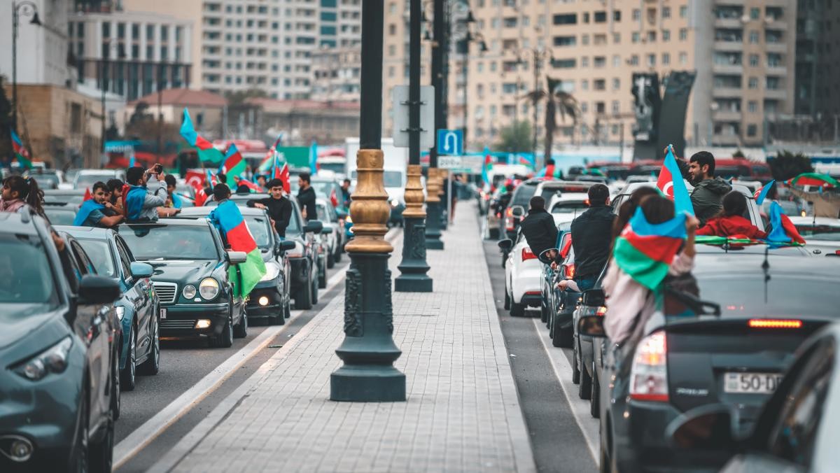 아제르바이잔 국경일에 도로에서 국기를 흔들고 있는 모습. / Khamid Bakhshiyev-shutterstock.com