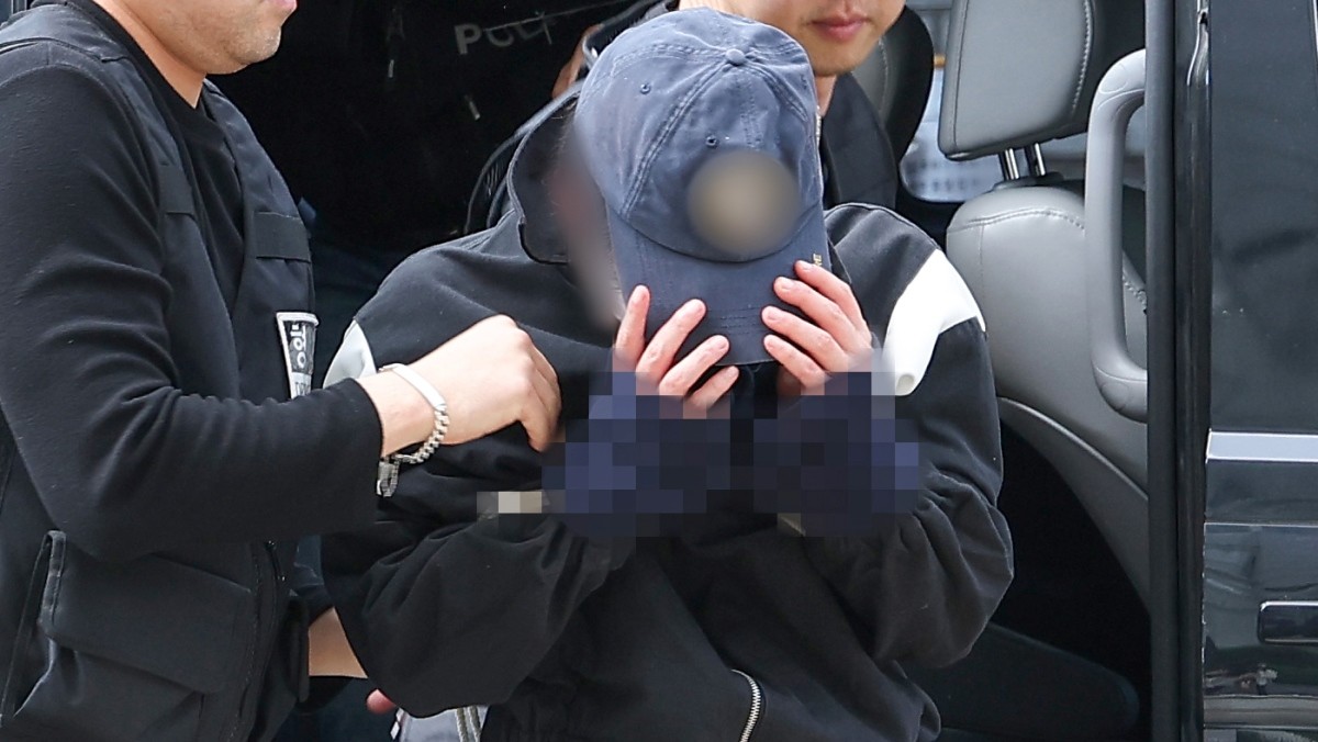 강남역 인근 건물 옥상에서 여자친구를 흉기로 살해한 혐의(살인)를 받는 20대 의대생이 지난해 서울 서초구 서울중앙지방법원에서 열린 구속 전 피의자 심문(영장실질심사)에 출석하며 얼굴을 가리고 있다. / 연합뉴스