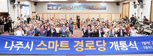 나주시 스마트경로당 개통식에 참석한 시민과 관계자들이 단체 기념사진을 찍고 있다.