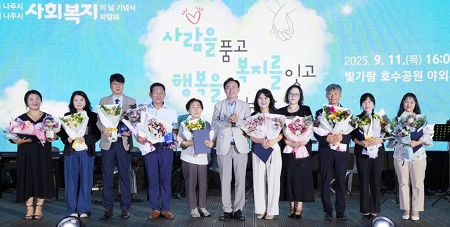 제1회 나주시 사회복지박람회에서 윤병태 시장(가운데)과 유공자 표창 수상자들이 단체 기념사진을 찍고 있다