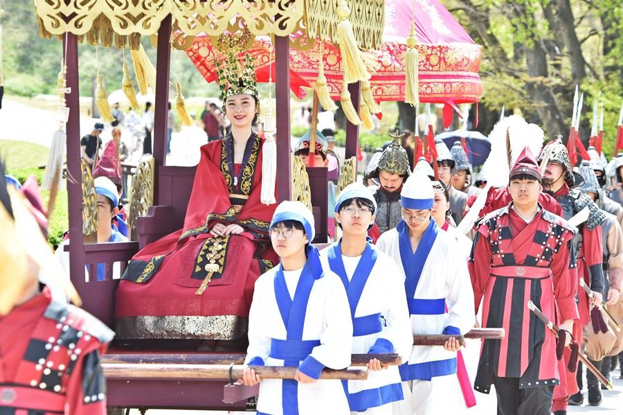 경주시 동부사적지에서 열린 ‘신라 선덕여왕 첨성대에 행차하다’ 행사에서 선덕여왕 복식으로 분장한 인물이 가마(보연)를 타고 행렬을 재현하고 있다./경주시