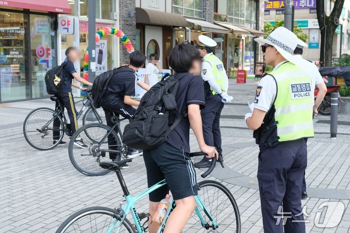 지난 15일 오후 서울 강동구 고덕역 인근에서 김성현 강동경찰서 교통안전계 경장이 학생들에게 브레이크 없는 픽시자전거 탑승 행위에 주의를 당부하고 있다 / 뉴스1