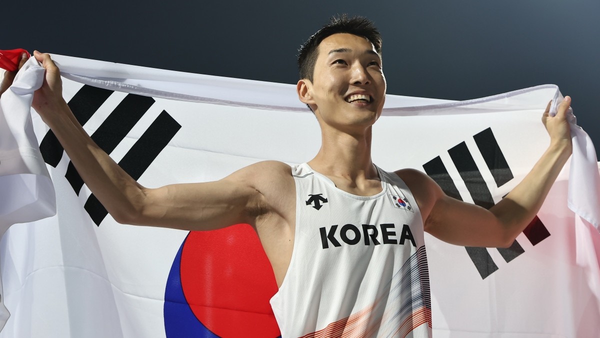 우상혁이 지난 5월 경북 구미시민운동장에서 열린 '2025 구미 아시아육상선수권대회' 높이뛰기 결승에서 2m29 기록으로 우승 확정 후 태극기를 두르고 기뻐하고 있다. / 뉴스1