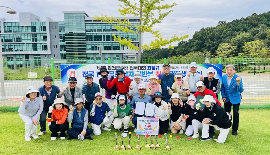 전국 파크골프대회 일반부 우승자인 최정규(가운데) 씨가 영진전문대 파크골프경영과 재학생·교수와 함께 기념촬영을 하고 있다. / 영진전문대 제공