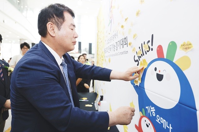이정선 광주시교육감이 22일 광주 김대중컨벤션센터 컨벤션홀에서 진행한 ‘제60회 전국기능경기대회’ 개막식에서 격려 문구를 담은 스티커를 응원판에 붙이고 있다. / 광주시교육청 제공