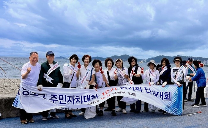 부산광역시 영도구 주민자치대학 12기 동기회는 지난 9월 20일, 회원 12명이 참여한 가운데 중리해변 일대에서 환경정비 활동 후 단체 기념 사진을 촬영하고 있다.{사진 좌측은 신기삼 동기회장) / 사진제공= 영도구 주민자치대학 12기 동기회