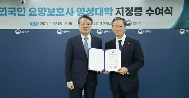 박상철 호남대학교 총장(왼쪽)이 정성호 법무장관으로부터 외국인 요양보호사 양성대학 지정증을 받고 있다.