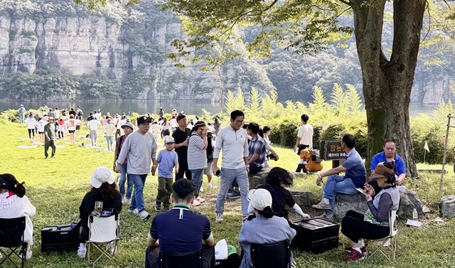 적벽을 배경으로 망미정 앞 잔디광장에서 축제를 즐기는 관광객들