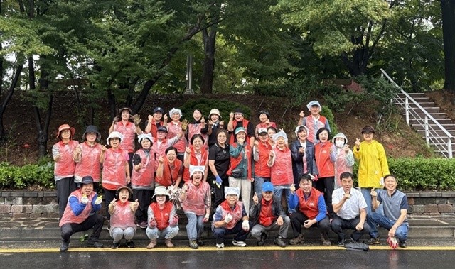 25일 순천시 왕조1동 통장협의회 관계자들이 행정복지센터 앞 ‘왕조꽃동산’에 가을꽃을 식재하고 단체사진을 촬영하고 있다.
