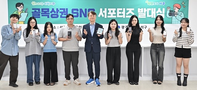 김이강 광주 서구청장이 25일 서구 소상공인경영지원센터에서 열린 '서구 골목상권 SNS 서포터즈 발대식'에서 위촉장을 수여한 후 참석자들과 기념촬영을 하고 있다. 광주 서구 제공