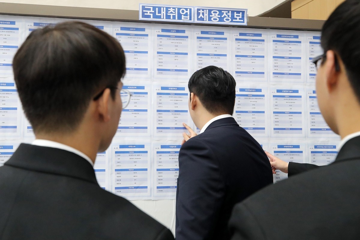 취업박람회를 찾은 20대 남성 구직자들이 일자리 정보를 살펴보고 있다. / 뉴스1