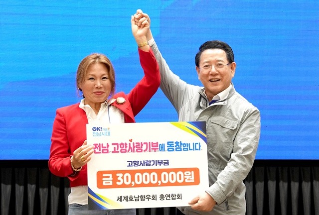 김영록 전라남도지사가 3일 오후 무안 남악 스카이웨딩컨벤션에서 열린 세계호남향우회총연합회 행사에서 이기자 총연합회장으로부터 고향사랑기부금을 전달받고 있다.