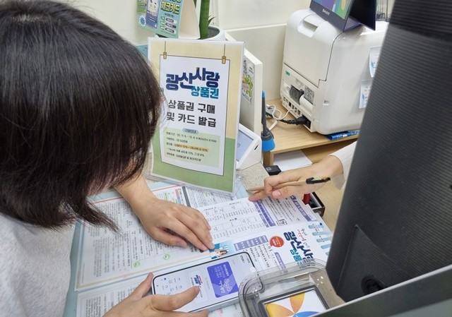 농협은행 광산구청출장소에서 은행 직원이 시민에게 광산사랑상품권 발행과 관련된 안내를 하고 있다.