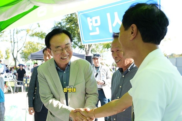 윤병태 시장(왼쪽)이 읍면동 부스를 방문해 축제장을 찾은 주민과 반갑게 인사를 나누고 있다.