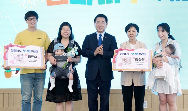 김영록 전라남도지사가 13일 전남도립도서관에서 열린 복합문화공간 ‘문화마루’ 개관 행사에 참석해 2025 출산 가정에게 책을 전달한 뒤 기념촬영을 하고 있다.