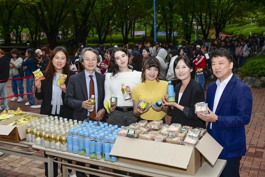 ;영진전문대 ‘간식 나눔’ 행사에서 간식을 받아 든 외국인 유학생들이 박종백 부총장(왼쪽서 두 번째) 등 보직 교수와 기념 촬영을 하고 있다. / 영진전문대 제공
