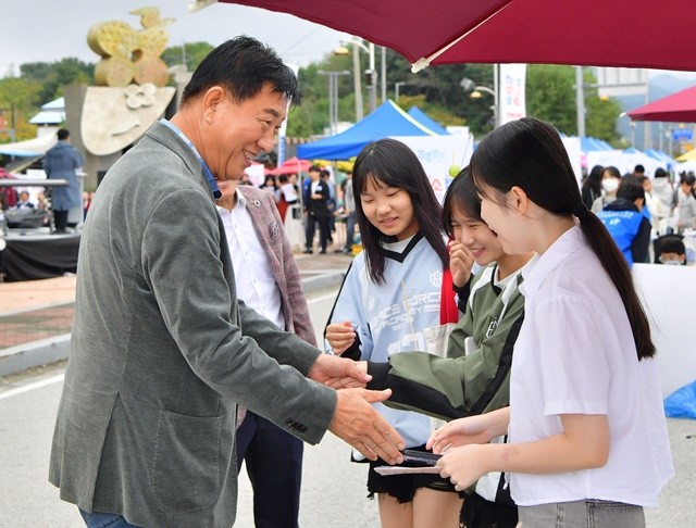 김한종 장성군수가 지난해 가을 청소년수련관 앞에서 청소년들과 인사하고 있다. 장성군 제공