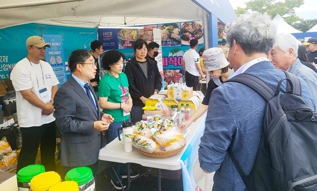 강상구 나주시 부시장(왼쪽)이 나주배 홍보관을 찾은 방문객들에게 시식을 권유하며 나주배 홍보에 열을 올리고 있다.