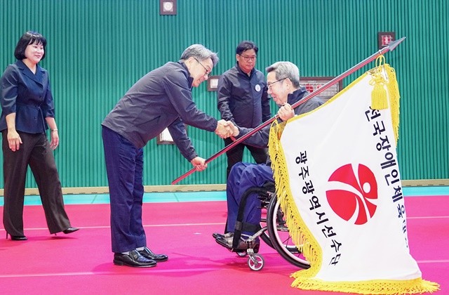 강기정 광주광역시장이 17일 오전 서구 장애인국민체육센터에서 열린 '제45회 전국장애인체육대회 광주선수단 결단식'에 참석해  한상득 광주시장애인체육회 수석부회장에게 단기를 전달하고 있다./광주광역시 제공