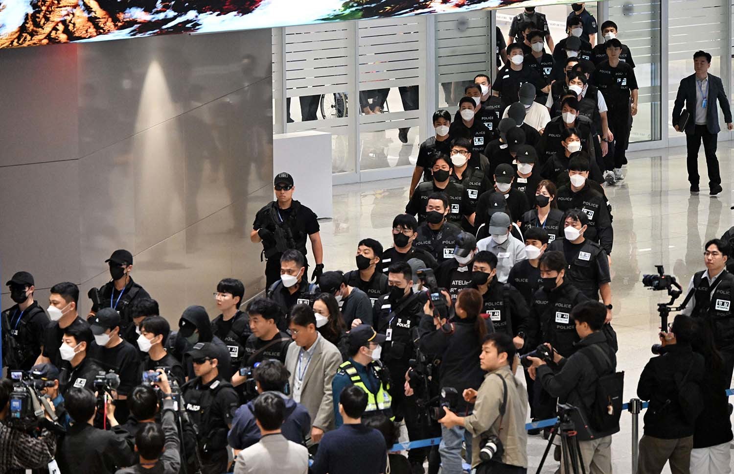 캄보디아 당국의 범죄단지 단속으로 적발돼 구금됐던 한국인들이 18일 오전 인천국제공항 2터미널을 통해 송환되고 있다. 이번 송환 대상자들은 이른바 '웬치'로 불리는 캄보디아 범죄단지에서 보이스피싱이나 로맨스 스캠(사기) 등 범죄에 가담한 혐의를 받고 있다. 이들은 호송 차량 23대 등을 타고 충남경찰청 등 6개 관할 경찰관서로 압송된다. / 뉴스1