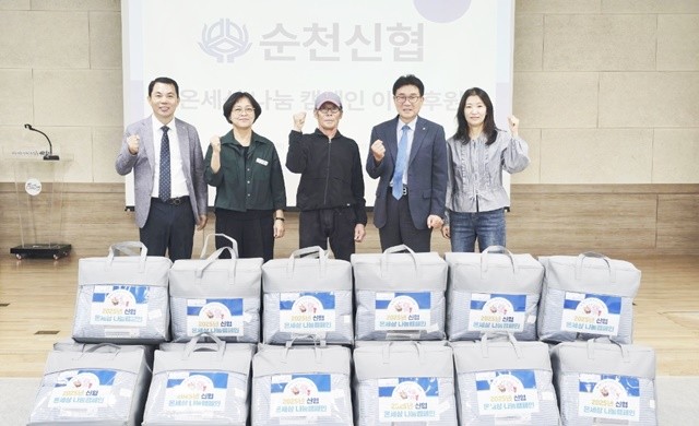 지난 16일 순천신협 관계자들이 왕조1동에 이불 18채를 전달하고 기념사진을 촬영하고 있다.