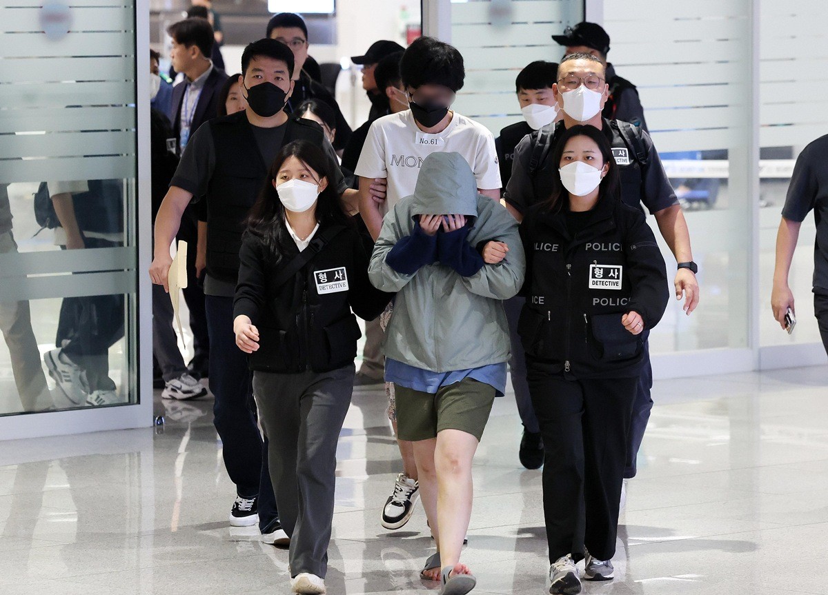 캄보디아 당국의 범죄단지 단속으로 적발돼 구금됐던 한국인들이 18일 수갑을 찬 채 인천국제공항 2터미널을 통해 송환되고 있다. / 뉴스1