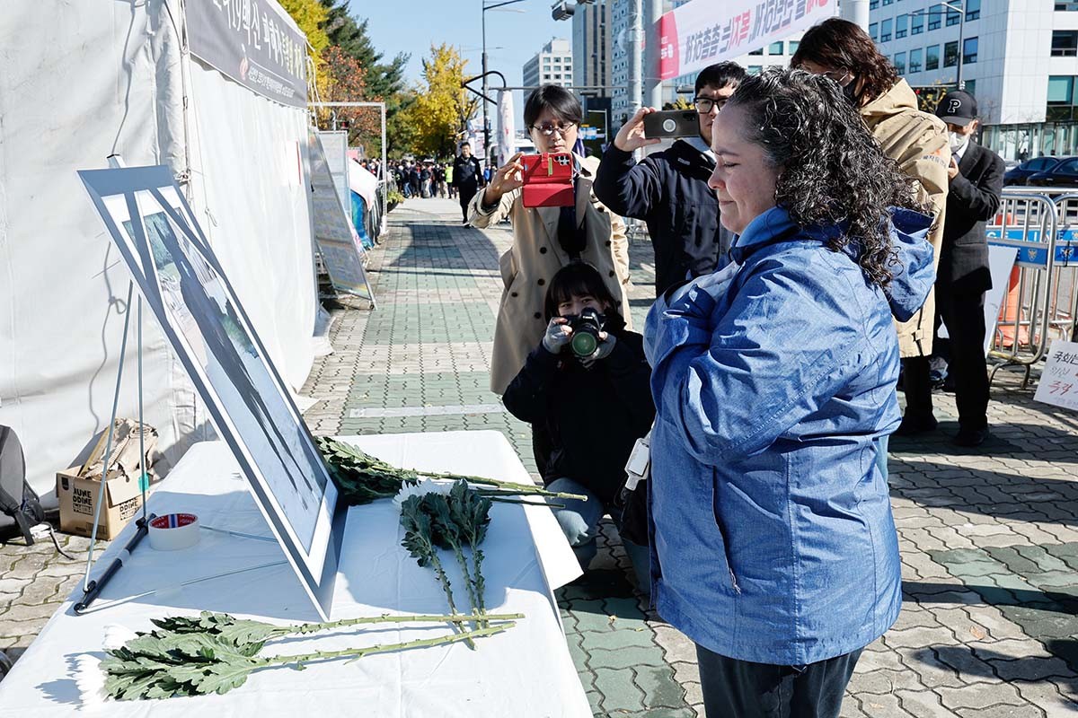 동물을 인도적으로 사랑하는 사람들(PETA)의 한나 활동가가 2023년 11월 7일 서울 영등포구 여의도 국회 앞에서 '까미(마리아주) 사망 2주기 추모 및 동물보호법 개정안 통과 촉구 기자회견'을 마친 뒤 까미의 영정 앞에 헌화하고 있다. 생명환경권행동 제주비건, 동물권단체 하이, 동물권행동 카라, 동물자유연대, 페타(PETA) 등 총 11개 단체는 당시 KBS1 드라마 ‘태종 이방원’ 촬영 중 사망한 퇴역 경주마 까미의 2주기를 맞아 국회를 향해 퇴역 경주마 보호를 위한 법안을 조속히 처리 할 것, 정부와 한국마사회를 향해 최소한의 말 복지 시스템을 마련할 것을 촉구했다. / 뉴스1 자료사진