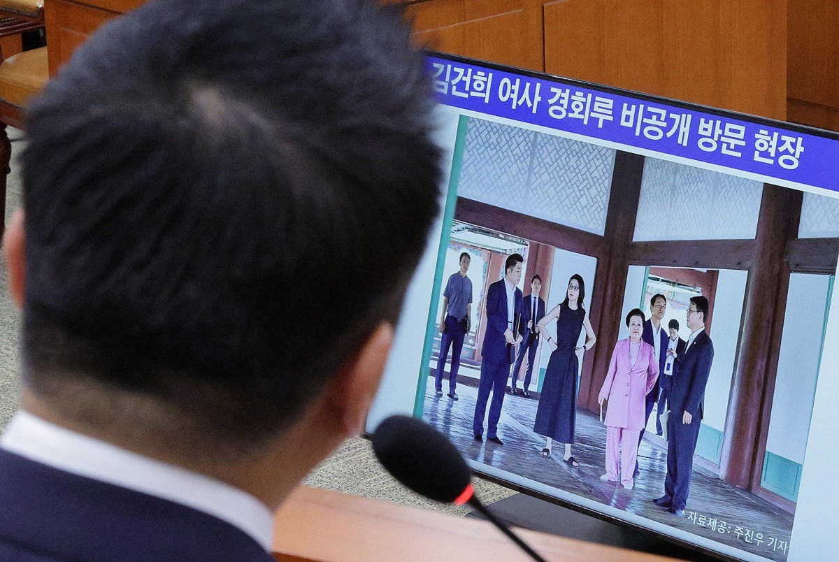 정용석 국립박물관문화재단 사장이 22일 국회 문화체육관광위원회에서 열린 국정감사에서 김건희 여사와 이배용 전 국가교육위원장 등이 2023년 9월 경복궁 경회루를 방문했을 때의 사진을 바라보고 있다. / 뉴스1