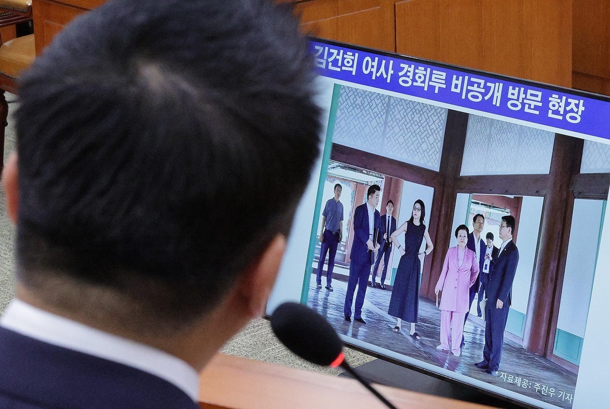 정용석 국립박물관문화재단 사장이 22일 국회 문화체육관광위원회에서 열린 국정감사에서 김건희 여사와 이배용 전 국가교육위원장 등이 2023년 9월 경복궁 경회루를 방문했을 때의 사진을 바라보고 있다. / 뉴스1