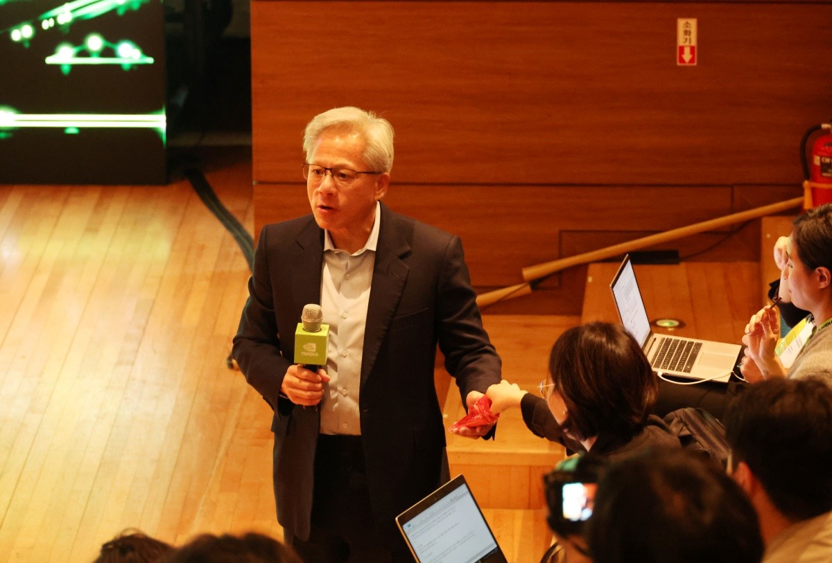 젠슨 황 엔비디아 최고경영자가 31일 경북 경주 예술의전당 원화홀에서 열린 2025년 아시아태평양경제협의체(APEC) 경주 엔비디아 기자간담회에서 질문을 들으며 취재진들에게 빼빼로 과자를 나눠주고 있다. / 연합뉴스