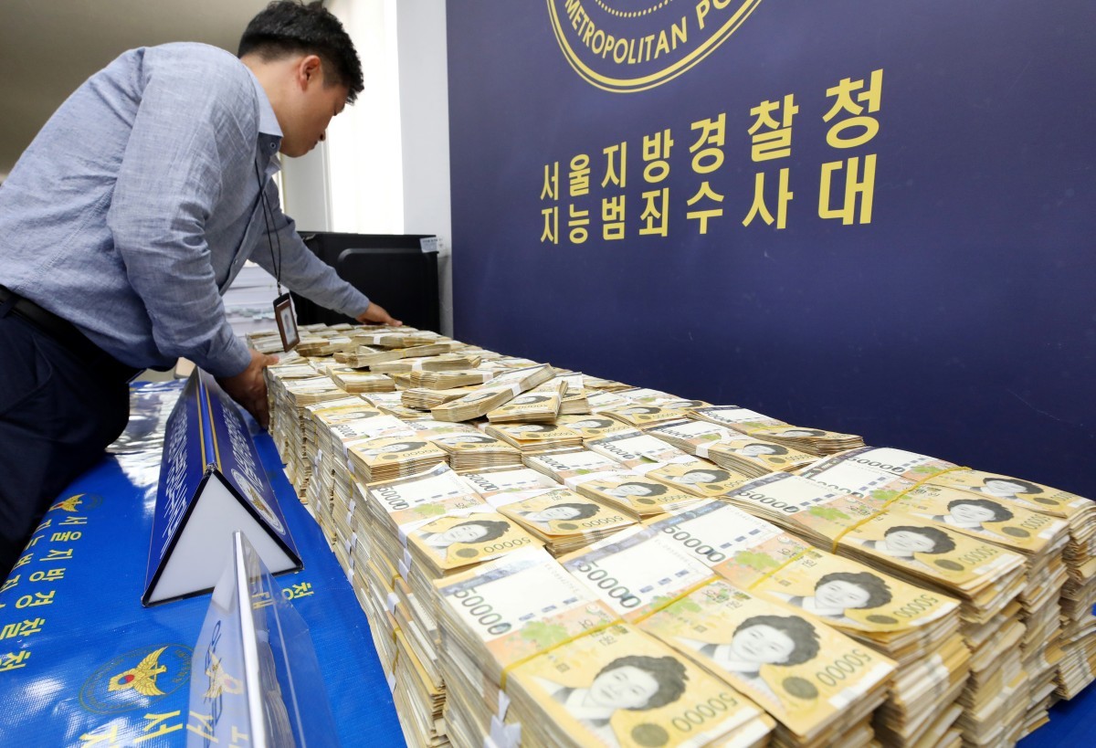 2018년 서울경찰청 지능범죄수사대(지수대)에서 경찰 관계자가 불법 스포츠 도박 사이트를 운영한 일당으로부터 압수한 현금을 진열하고 있다. 기사의 이해를 돕기 위한 사진 / 뉴스1