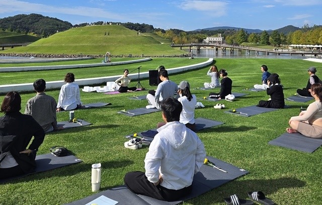 순천만국가정원 호수정원에서 선라이즈요가 및 싱잉볼 명상에 참여하고 있는 관람객들