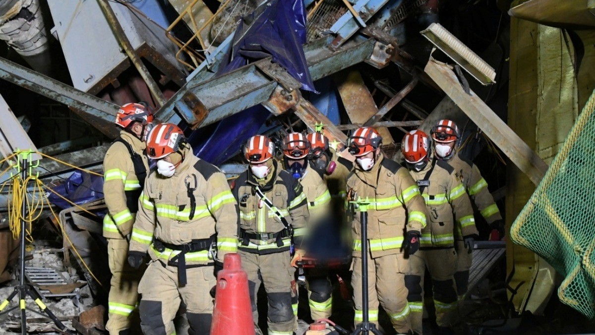 12일 오전 울산화력발전소 붕괴 현장에서 수습된 매몰자를 구조대원들이 들것을 이용해 붕괴된 건물 밖으로 나오고 있다. / 소방청 제공, 뉴스1