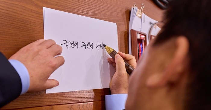 이재명 대통령이 11일 서울 용산 대통령실에서 대통령 취임 기념 손목시계의 뒷판에 들어갈 문구를 쓰고 있다. / 뉴스1