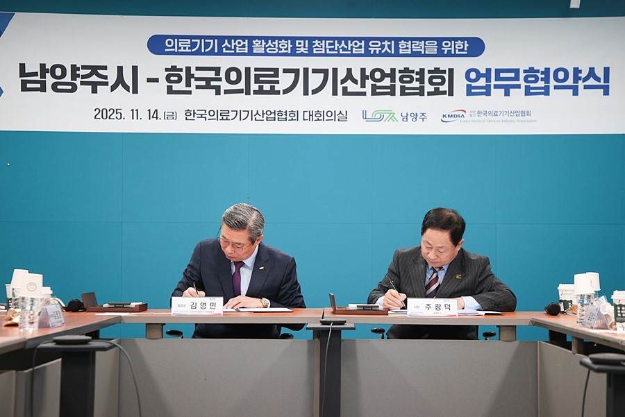 김영민 회장(좌)과 주광덕 시장(우)이 업무협약서에 서명하고 있다