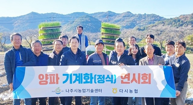 양파 기계 정식 연시회에 참가한 농업인들과 관계자들이 기념촬영을 하고 있다