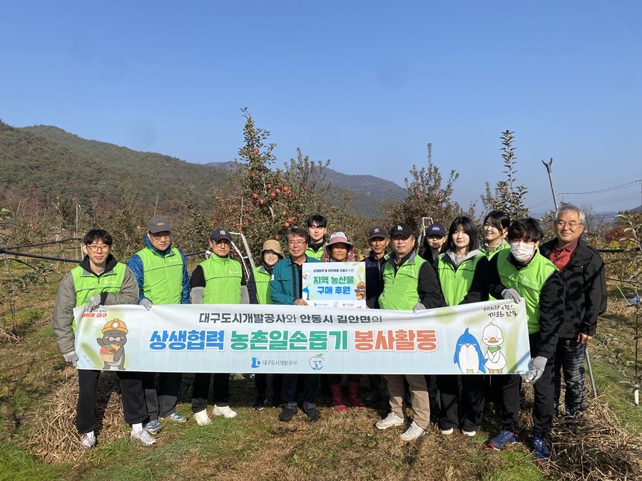 대구도시개발공사 청아람봉사단과 길안면 행정복지센터 관계자들이 안동시 길안면에 위치한 사과농가에서 일손돕기 봉사활동 후 기념촬영을 하고 있다.  / 대구도시개발공사 제공