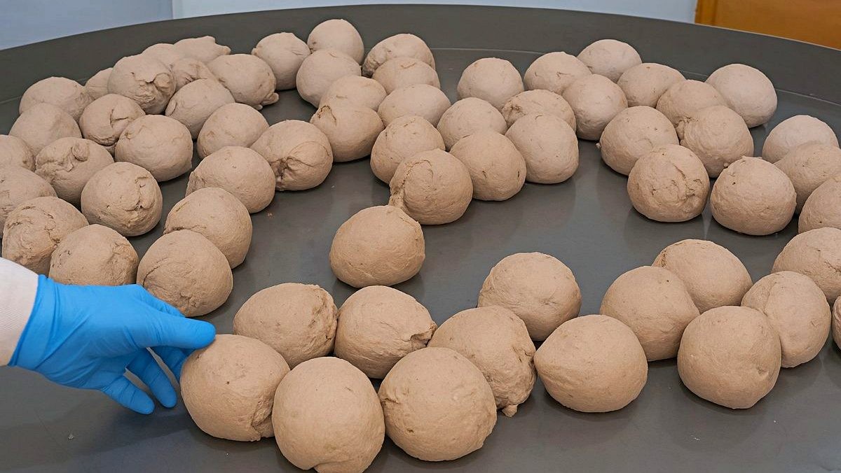 피자 대량생산 현장. 한꺼번에 제조되는 피자 도우 반죽. 기사 내용을 바탕으로 AI가 생성한 자료사진.