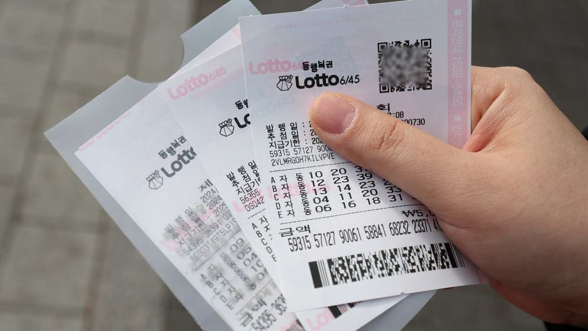한 시민이 구매한 로또를 들고 있다. / 연합뉴스