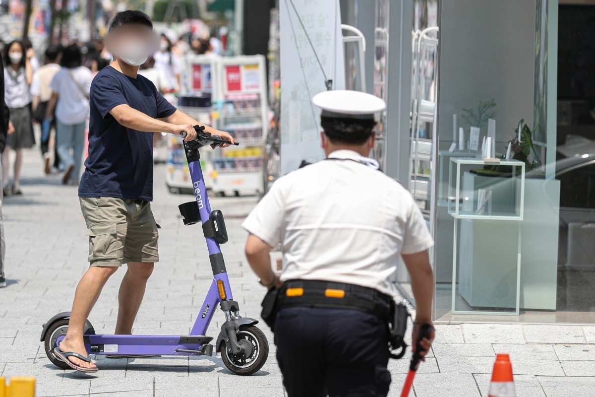 경찰이 헬멧을 미착용한 공유형 전동 킥보드를 이용자를 단속하고 있다. 기사의 이해를 돕기 위한 사진. / 뉴스1