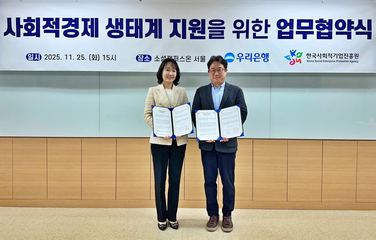 25일 서울시 성동구 성수동에 있는 ‘소셜캠퍼스온 서울1’에서 열린 사회적경제 생태계 지원을 위한 업무협약식에서 이현주(왼쪽) 우리은행 ESG상생금융부장과 서종식 한국사회적기업진흥원 기업성장본부장이 기념사진을 촬영하고 있다. / 우리은행